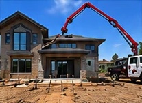 Boom pump beside a new custom home