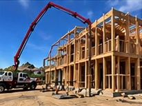 Boom pump at a framed apartment build