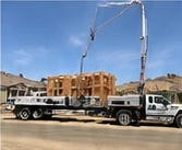 Bulldog truck with boom extended over a building site